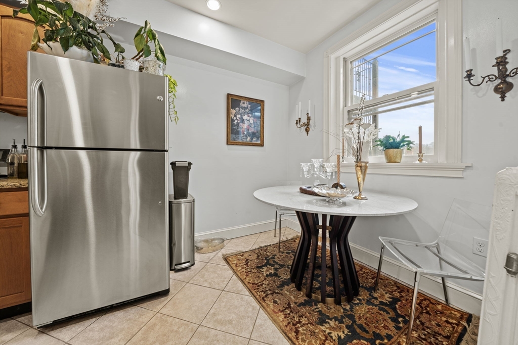 9 Regent Circle, Unit 3 Brookline, MA 02445 - Photo 4 of 20 a kitchen with a refrigerator a table and chairs