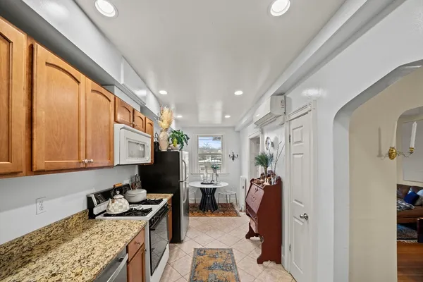 a kitchen with stainless steel appliances granite countertop a stove refrigerator and a sink
