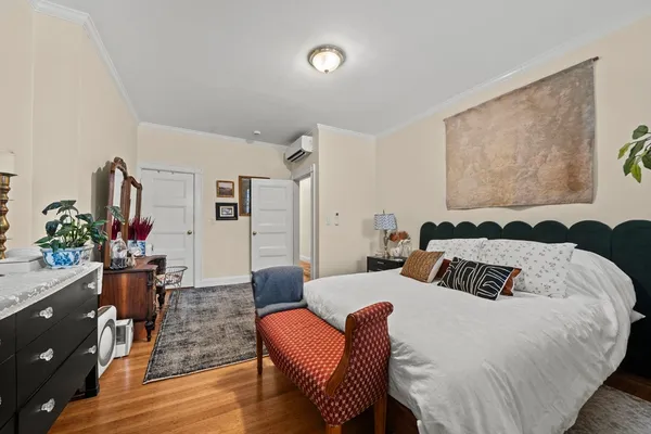 a bedroom with a bed and wooden floor