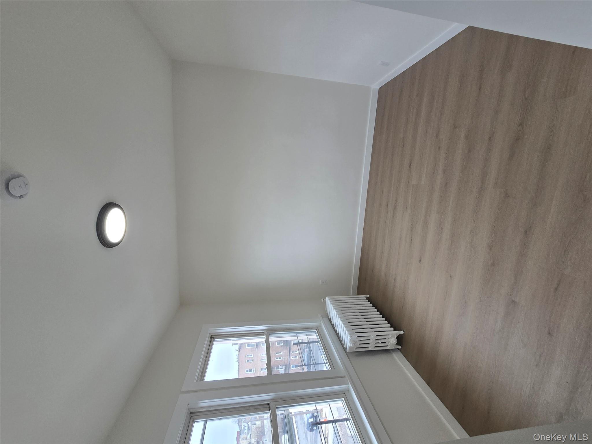 112 Webster Avenue, Unit 3 New Rochelle, NY 10801 - Photo 2 of 7 an empty room with wooden floor and windows