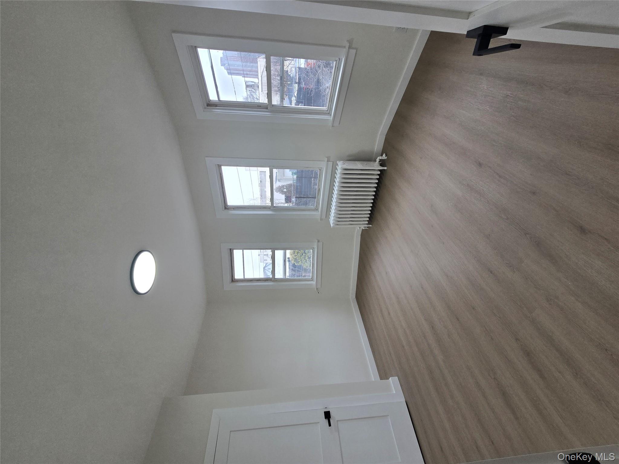 112 Webster Avenue, Unit 3 New Rochelle, NY 10801 - Photo 3 of 7 a view of an empty room with wooden floor and a window