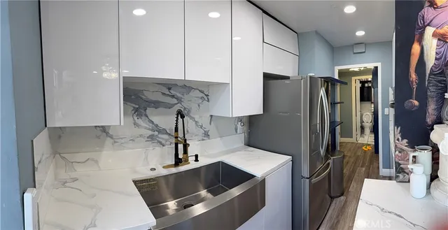 a kitchen with stainless steel appliances granite countertop a refrigerator and a sink