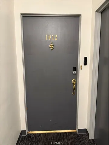 a view of a wooden door with a bench in front of house