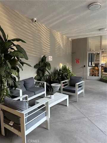 a view of a terrace with lawn chairs potted plants and city view