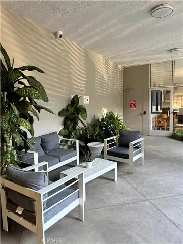 a view of a living room with furniture and floor to ceiling window