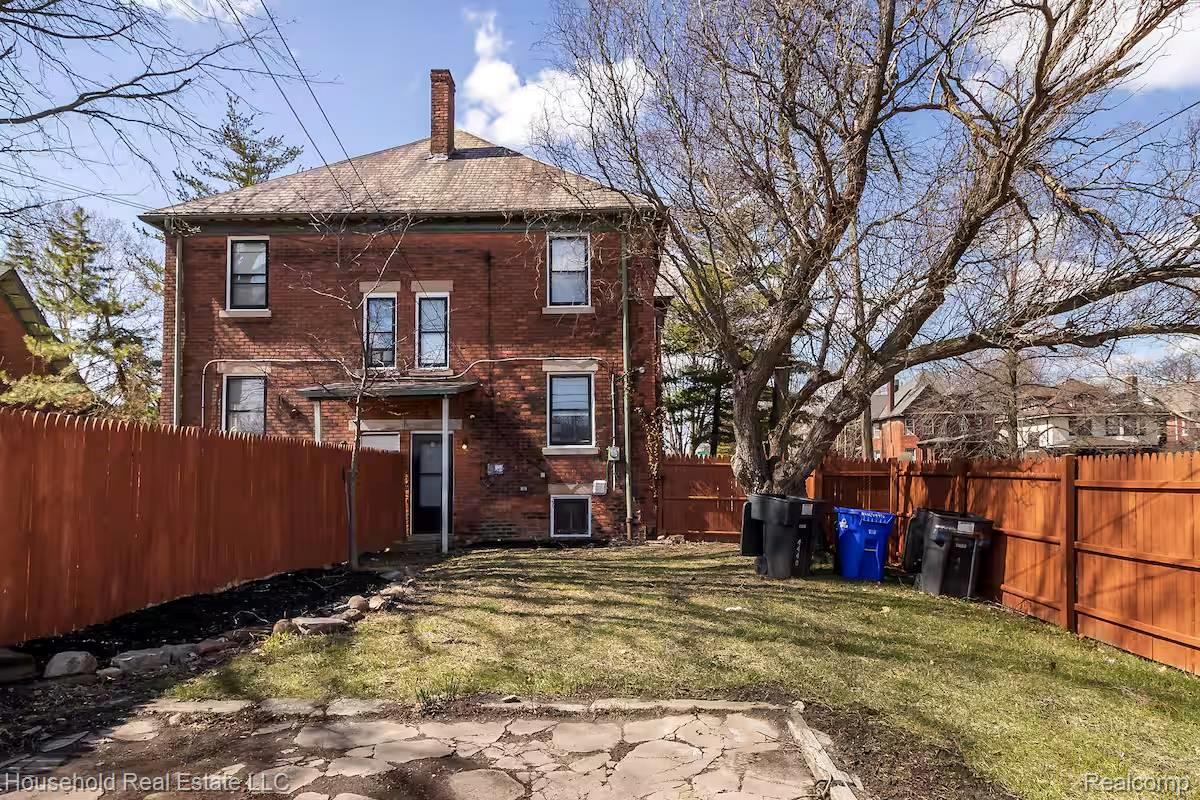 4446 Commonwealth Street Detroit, MI 48208 - Photo 28 of 28 Back of property with brick siding, a chimney, and a fenced backyard