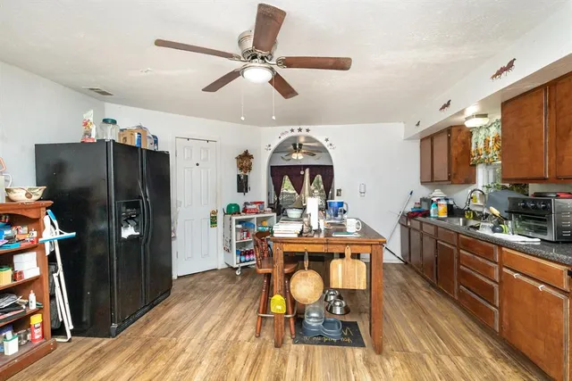 a view of a kitchen with dining area a refrigerator and wooden floor