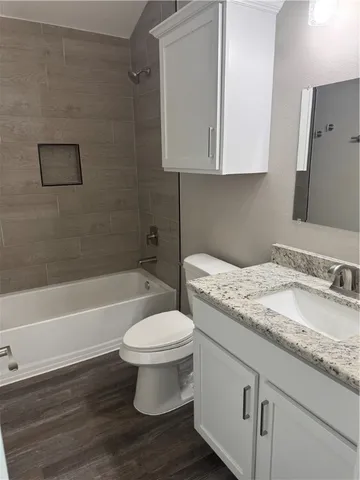 a bathroom with a granite countertop toilet a sink and bathtub