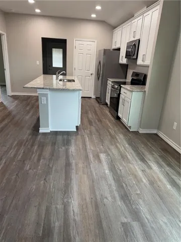 a kitchen with stainless steel appliances a refrigerator and a stove top oven