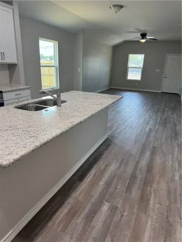 a view of kitchen with granite countertop cabinets and window