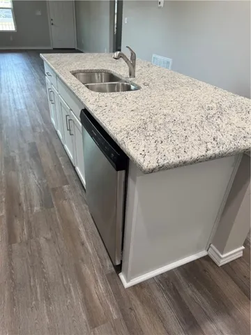 a kitchen with kitchen island sink stove and wooden floor
