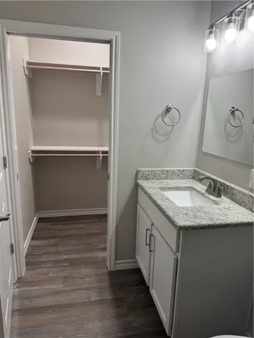 a bathroom with a granite countertop sink and washing machine
