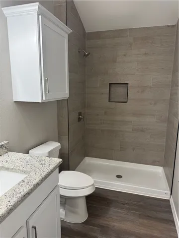a bathroom with a granite countertop bathtub shower sink and toilet