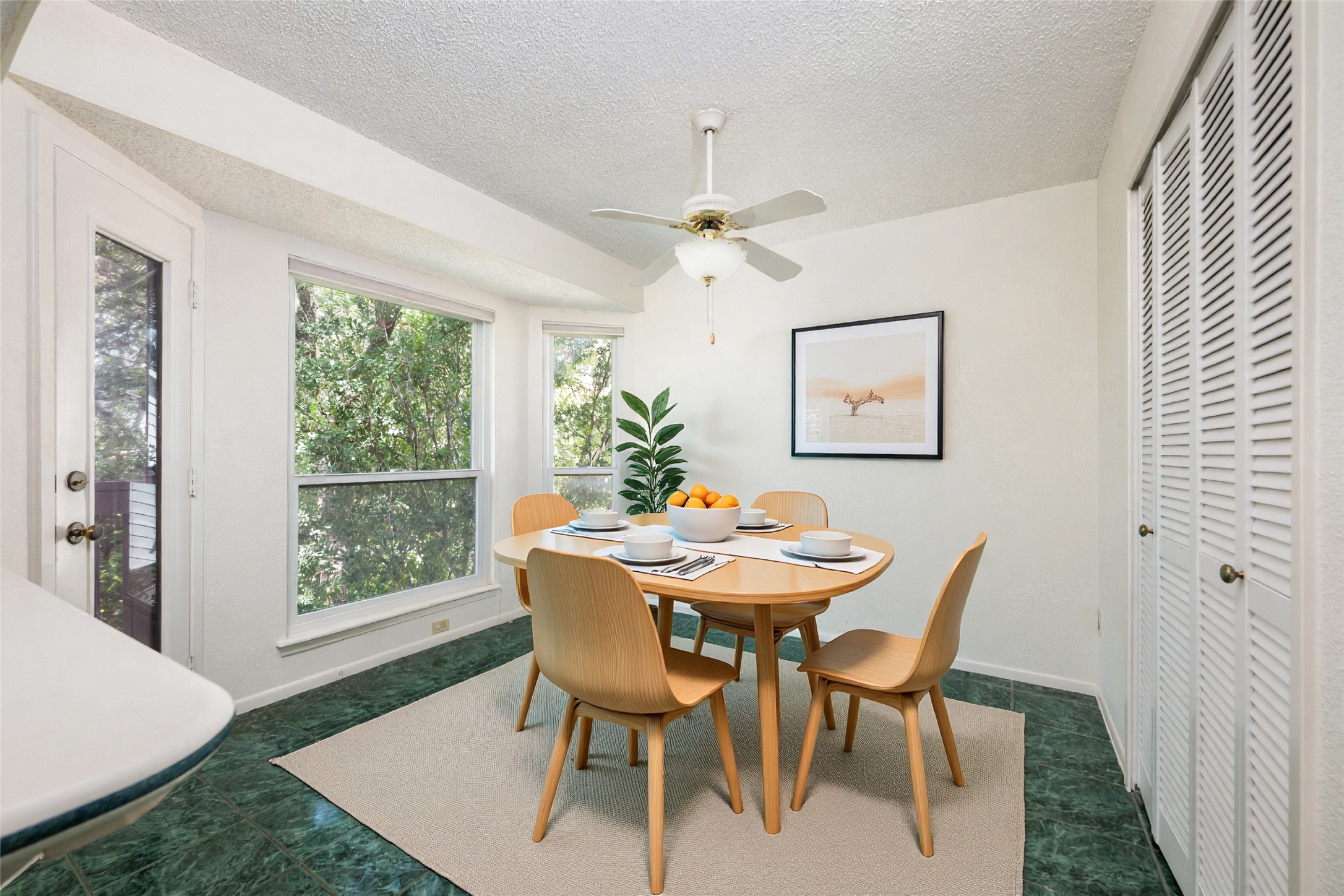 5319 Musket Ridge Austin, TX 78759 - Photo 18 of 39 A well-lit dining area featuring a light wood table, four matching chairs, and vibrant green tile flooring.