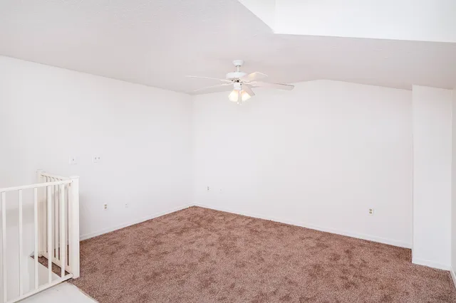 an empty room with a ceiling fan and a ceiling fan