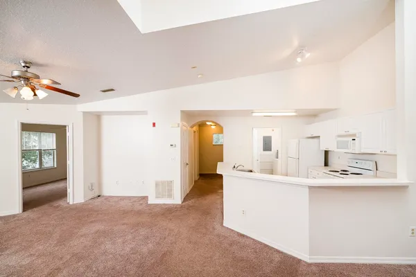 a large white kitchen with a large window