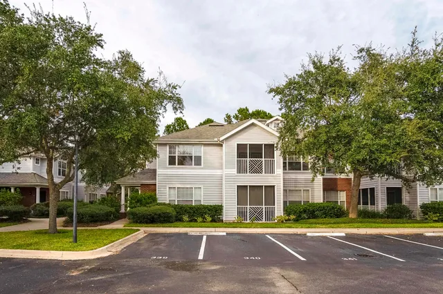 a view of a big house with a big yard and large trees