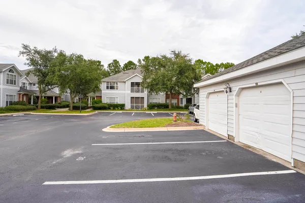a view of a white house with a swimming pool and a yard