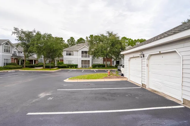 a view of a white house with a swimming pool and a yard