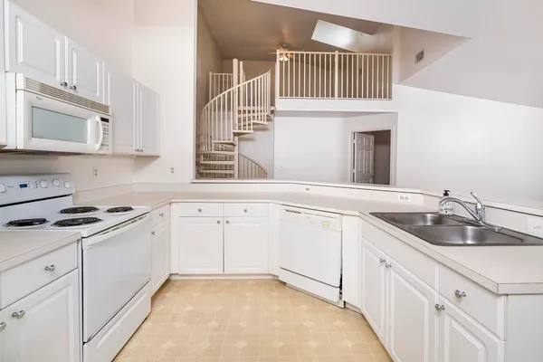 a kitchen with granite countertop a sink stove and cabinets