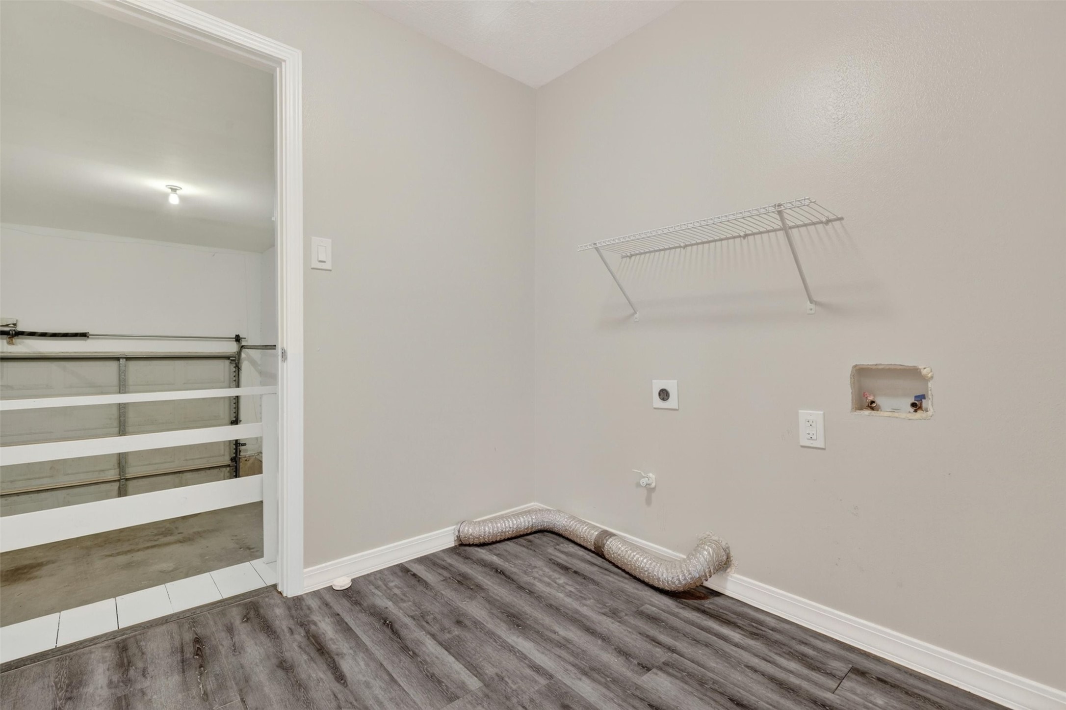 12929 Kingsbridge Lane Houston, TX 77077 - Photo 25 of 42 Conveniently located just off the garage, this spacious laundry room offers added functionality and everyday convenience buyers appreciate. Featuring durable modern flooring, ample wall space for storage solutions, and easy access to the main living areas, this versatile utility space helps keep household tasks organized and efficient. The practical layout provides room for full-size washer and dryer connections while maintaining a clean, move-in ready feel throughout the home.