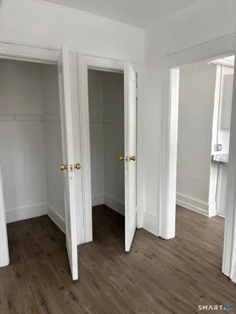 an empty room with wooden floor & entryway
