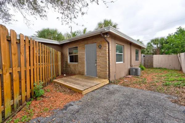 a view of backyard of house with wooden fence