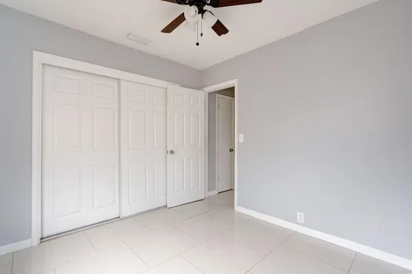 an empty room with a ceiling fan and carpet