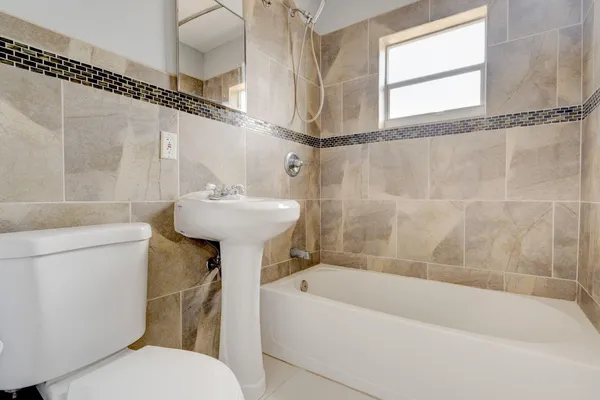 a bathroom with a sink a mirror toilet and bathtub