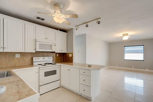 a kitchen with cabinets stainless steel appliances and a window