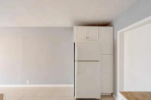 a view of kitchen with refrigerator and cabinet