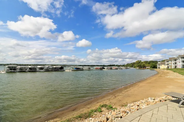 a view of a white house with a big yard and large trees