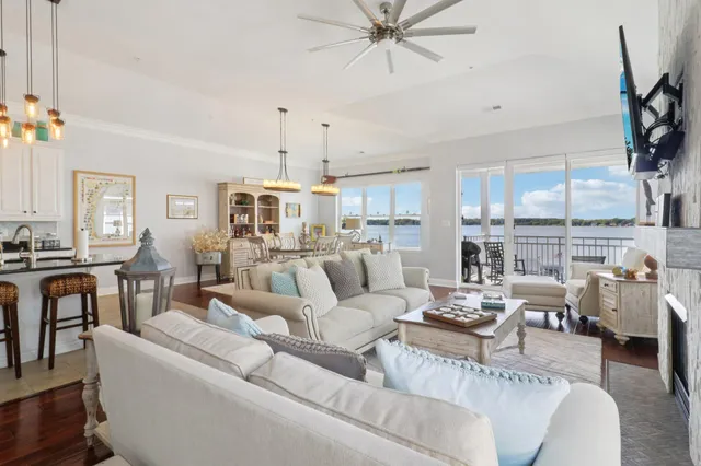 a living room with furniture kitchen view and a large window