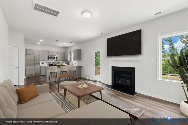 a living room with furniture a flat screen tv and a fireplace