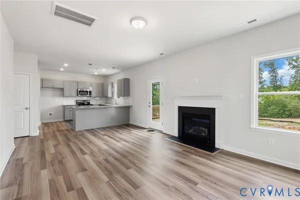 a view of kitchen with wooden floor and a fireplace