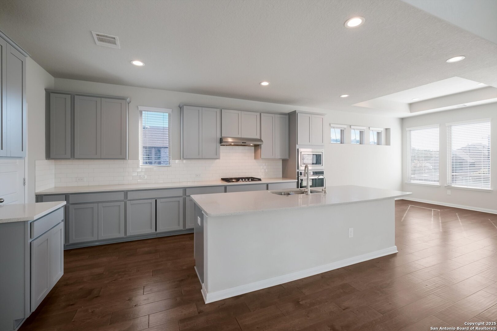 1718 Wind River San Antonio, TX 78258 - Photo 12 of 32 a kitchen with kitchen island a sink and a stove top oven