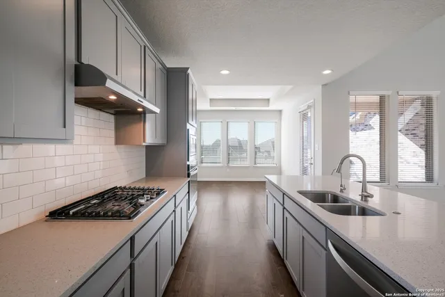 a kitchen with stainless steel appliances a sink stove and cabinets