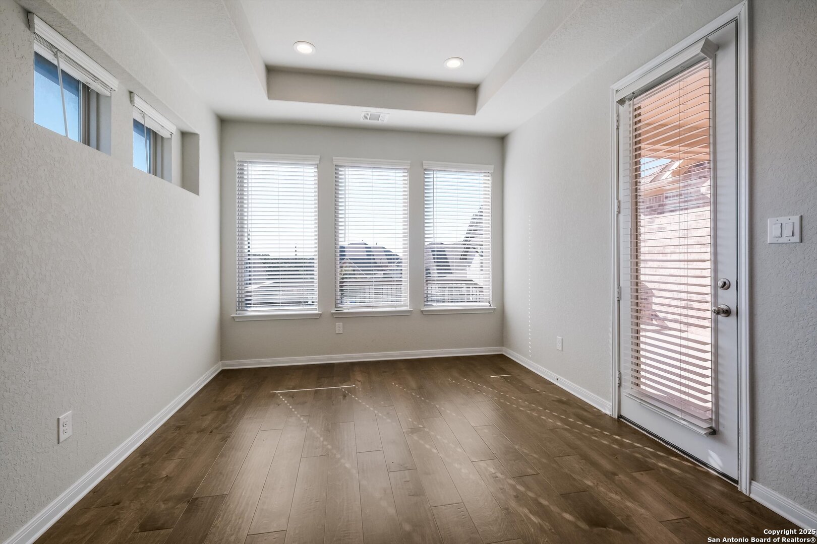 1718 Wind River San Antonio, TX 78258 - Photo 15 of 32 an empty room with wooden floor and windows