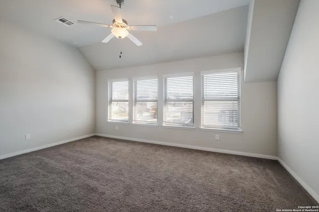 an empty room with a window and a fan