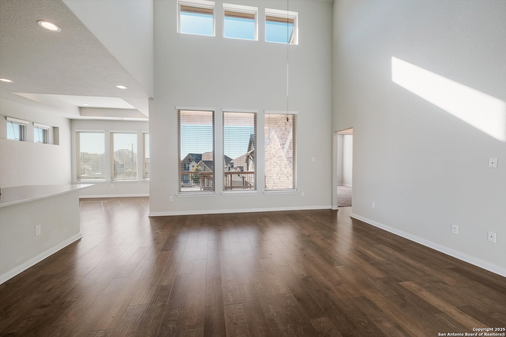 1718 Wind River San Antonio, TX 78258 - Photo 7 of 32 an empty room with wooden floor and windows