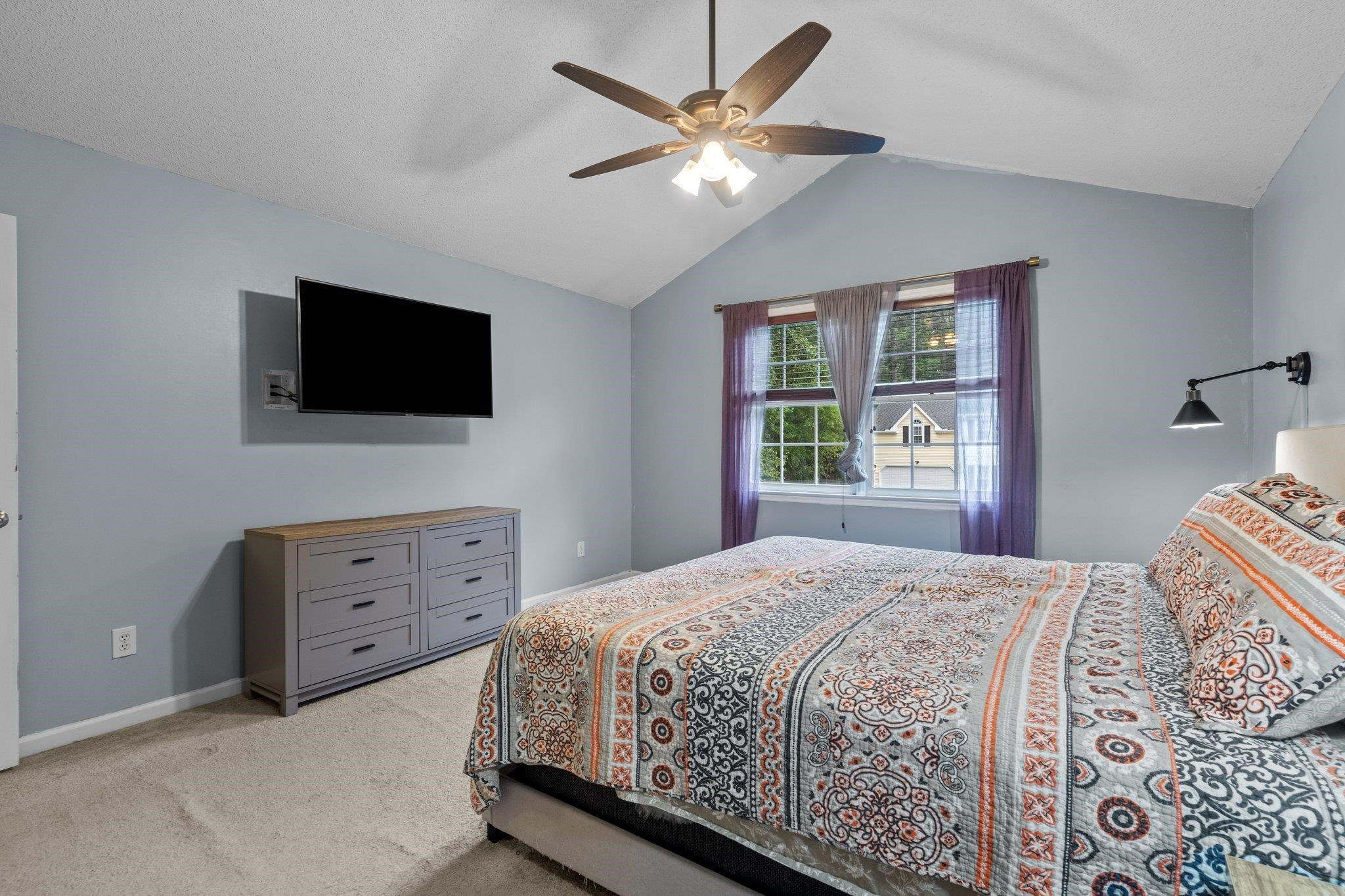 6305 Dry Fork Lane Raleigh, NC 27617 - Photo 21 of 41 a bedroom with a bed a window and a flat screen tv