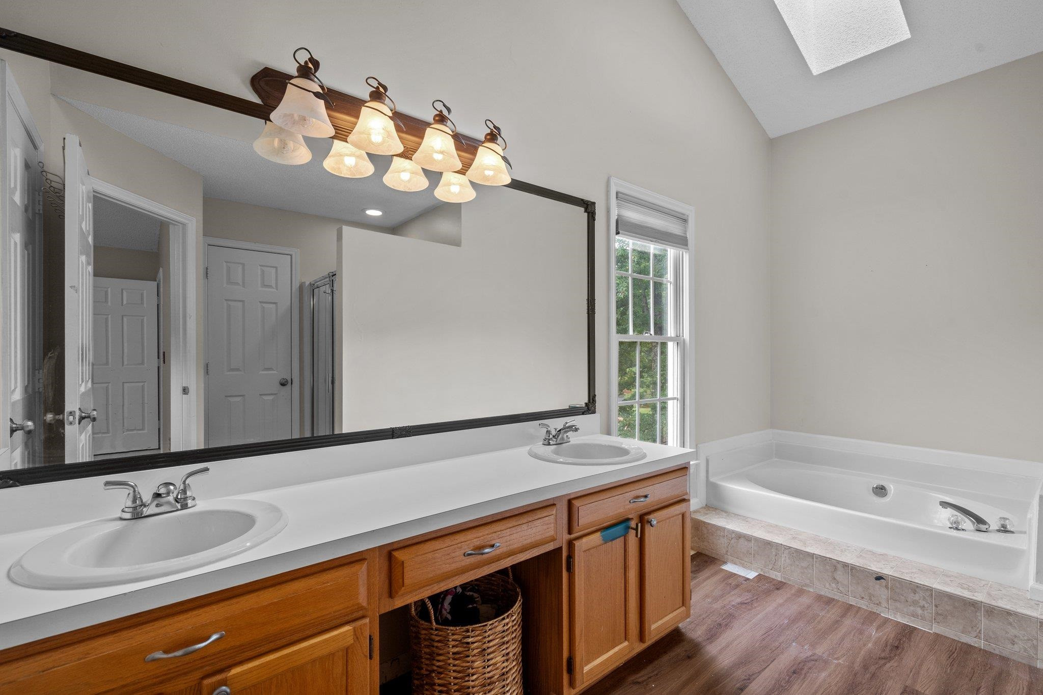 6305 Dry Fork Lane Raleigh, NC 27617 - Photo 23 of 41 a bathroom with a sink a large mirror and a bathtub with a mirror
