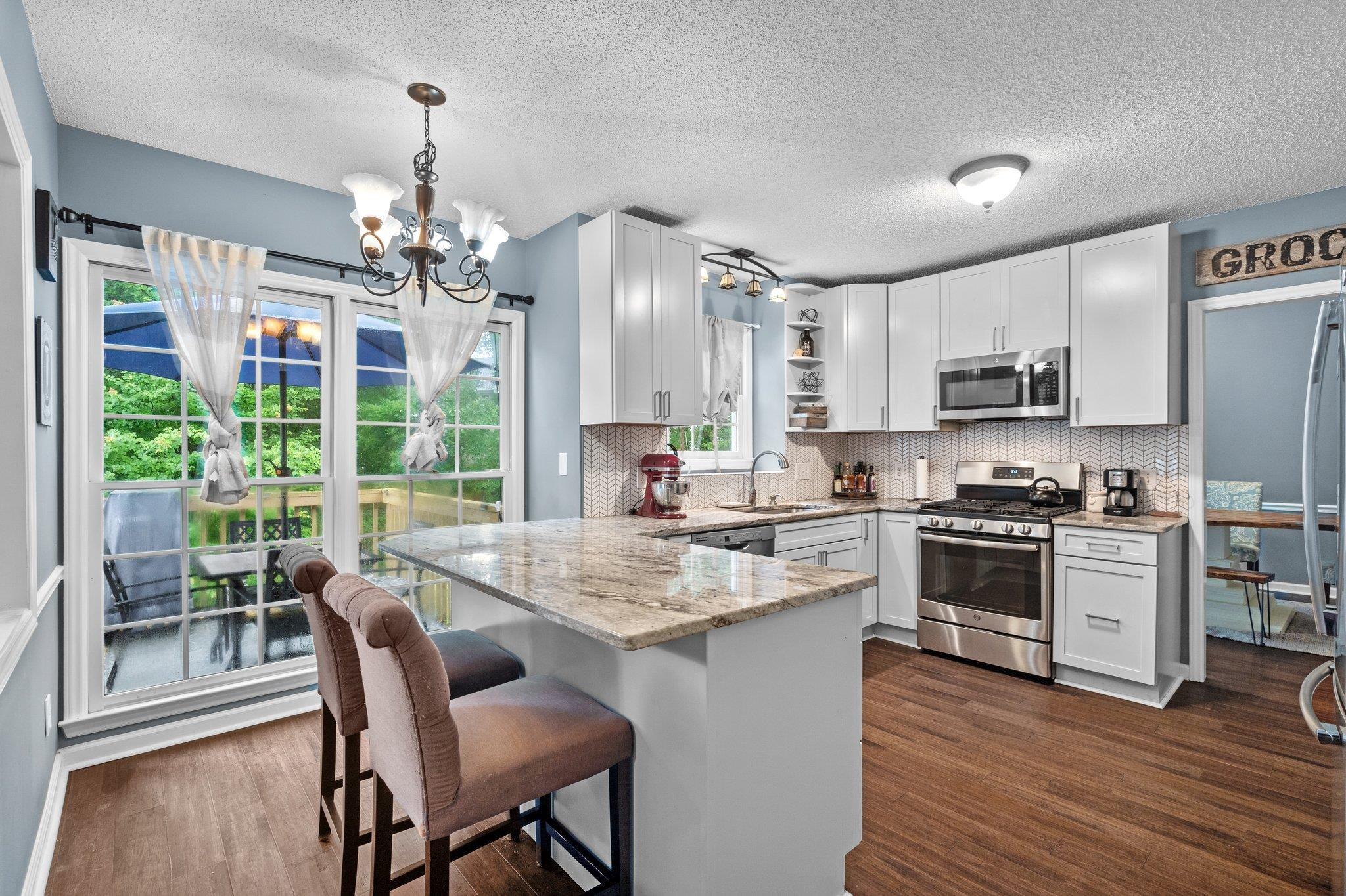 6305 Dry Fork Lane Raleigh, NC 27617 - Photo 3 of 41 a kitchen with stainless steel appliances granite countertop a stove top oven a refrigerator a sink dishwasher a dining table and chairs with wooden floor