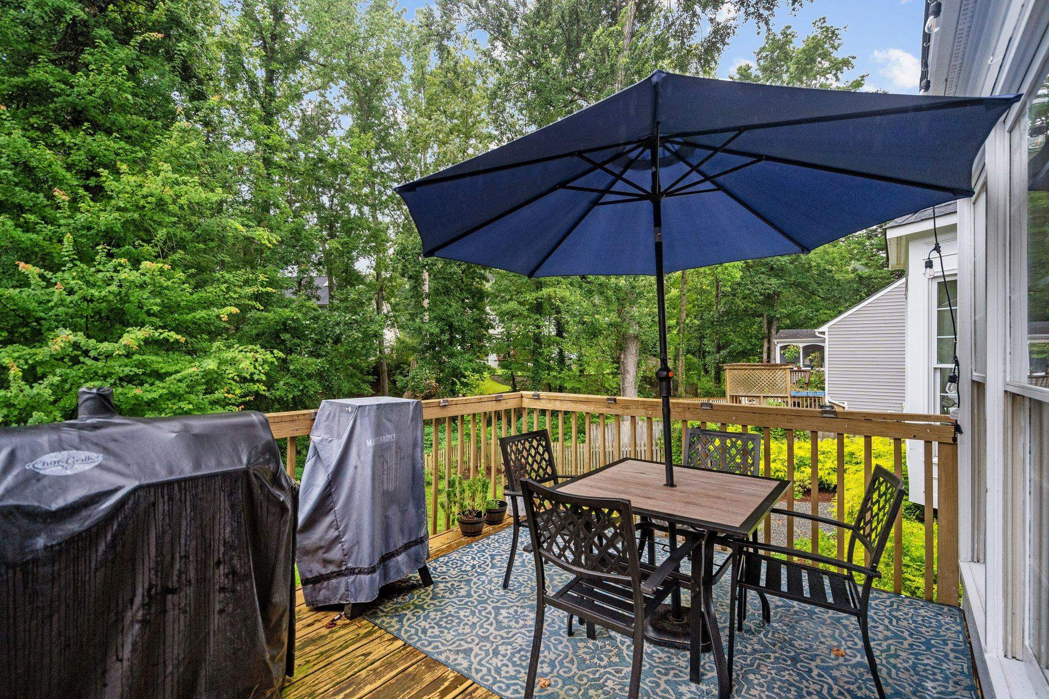 6305 Dry Fork Lane Raleigh, NC 27617 - Photo 37 of 41 a patio with wooden floor a yard a table and chairs