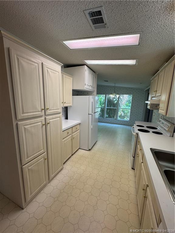 4236 Southeast Sweetwood Way Stuart, FL 34997 - Photo 14 of 50 a kitchen with white cabinets and white appliances