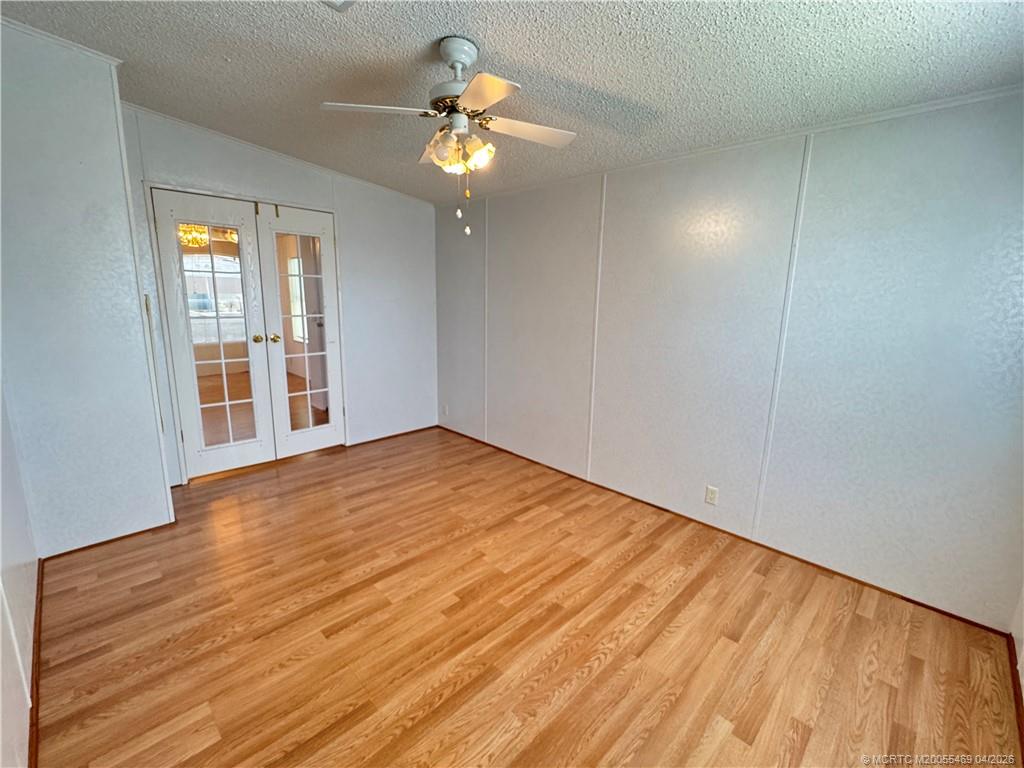 4236 Southeast Sweetwood Way Stuart, FL 34997 - Photo 18 of 50 a view of empty room with wooden floor and fan