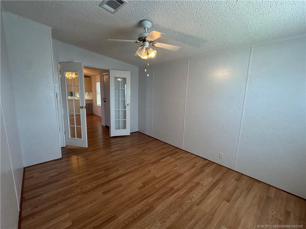 4236 Southeast Sweetwood Way Stuart, FL 34997 - Photo 19 of 50 a view of an empty room with wooden floor and a window