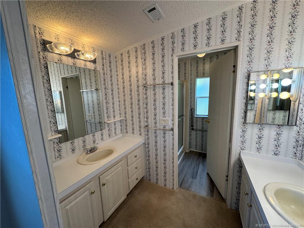 4236 Southeast Sweetwood Way Stuart, FL 34997 - Photo 23 of 50 a bathroom with a double vanity sink a toilet a mirror and shower