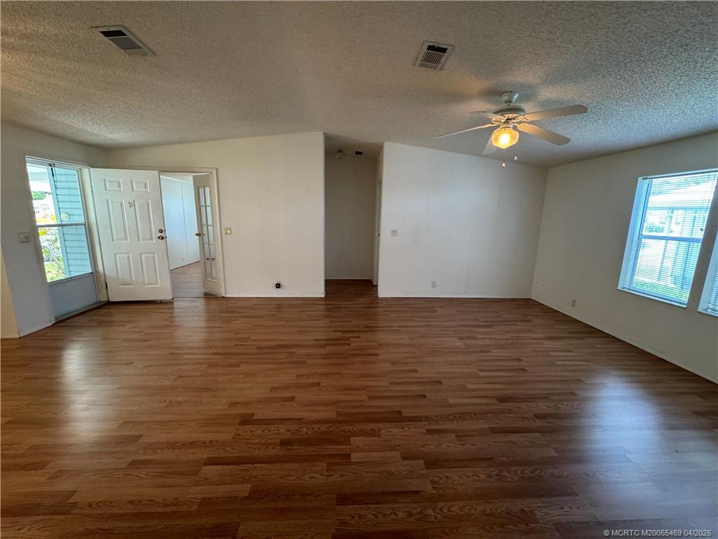 4236 Southeast Sweetwood Way Stuart, FL 34997 - Photo 4 of 50 an empty room with wooden floor and windows