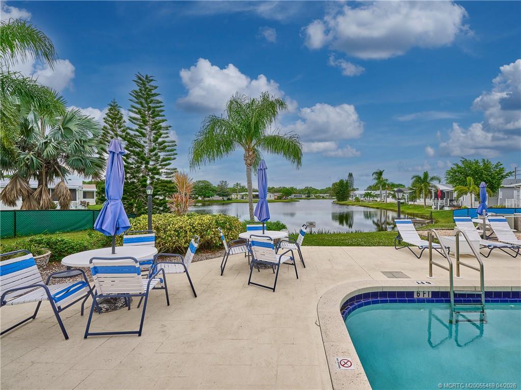4236 Southeast Sweetwood Way Stuart, FL 34997 - Photo 46 of 50 a view of a swimming pool with a table and chairs
